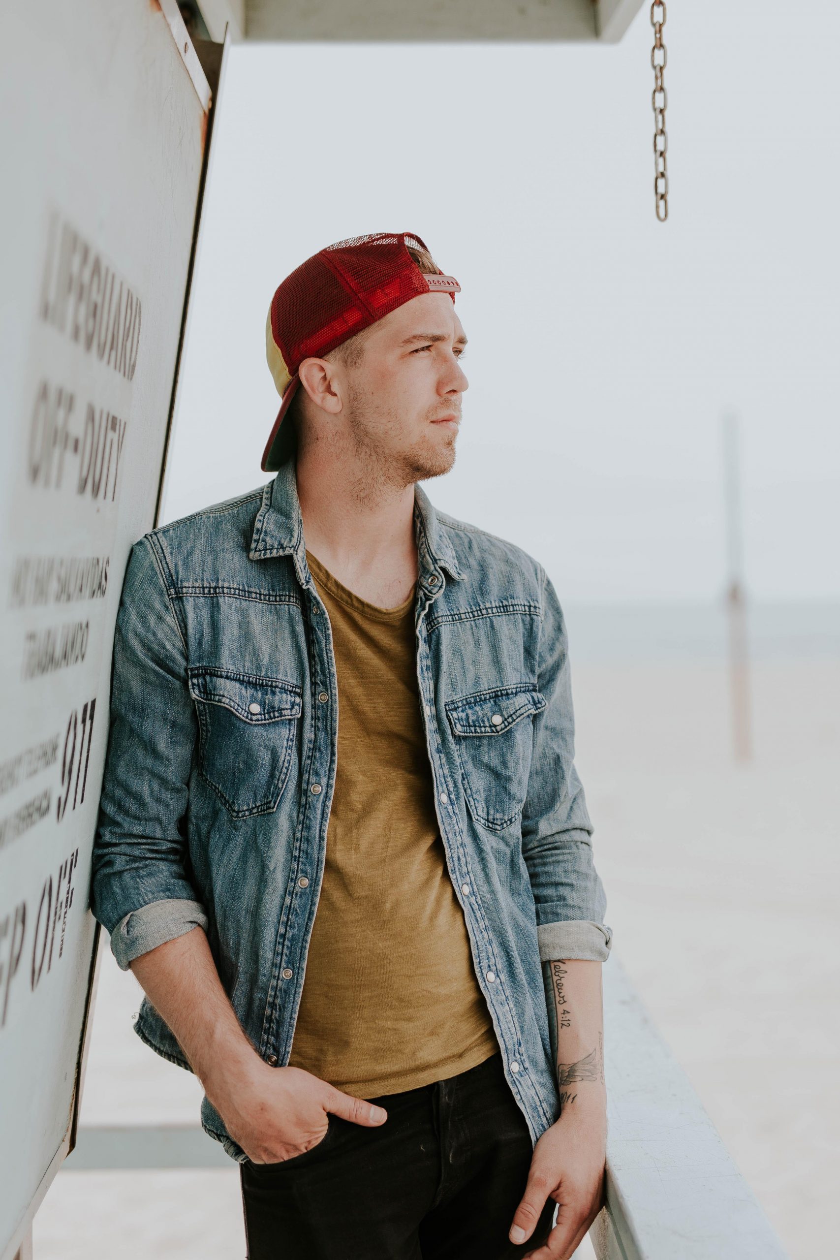 A man wearing red cap and denim jacket